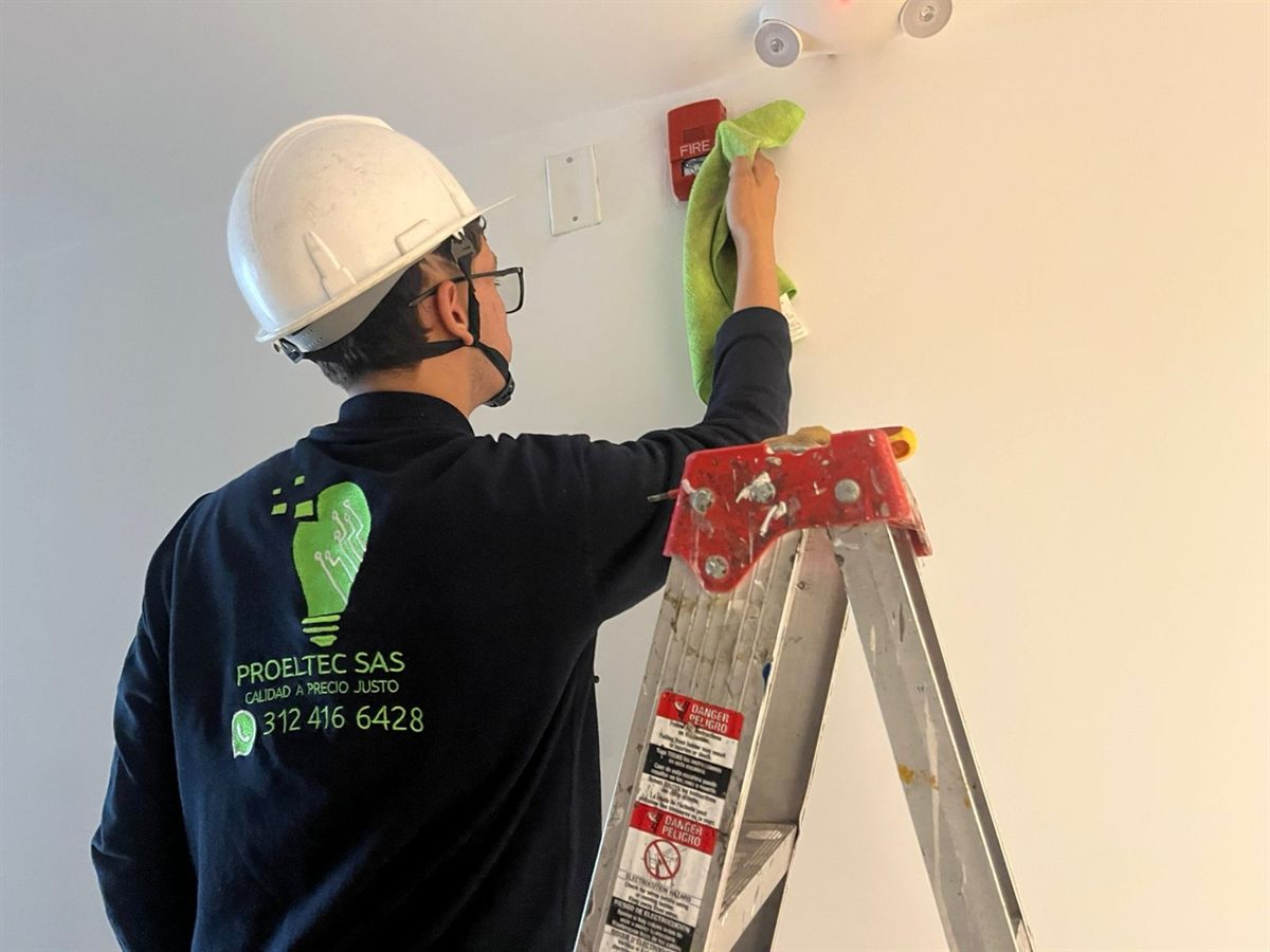 Técnico de Proeltec haciendo mantenimiento a un panel de alarma contra incendios
